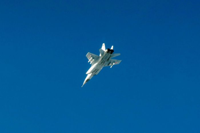 An illustrative photo of a Russian MiG-35 shows a sleek twin-engine multirole fighter jet with a pointed nose, wide delta-style wings and twin vertical stabilizers, painted in a light blue-gray camouflage with Russian Air Force insignia, parked or taxiing on an airfield under clear daylight.
