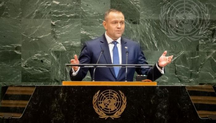 Karol Nawrocki delivering a speech at the United Nations in New York, captured in a Ukrinform screenshot. He is standing against the green marble background