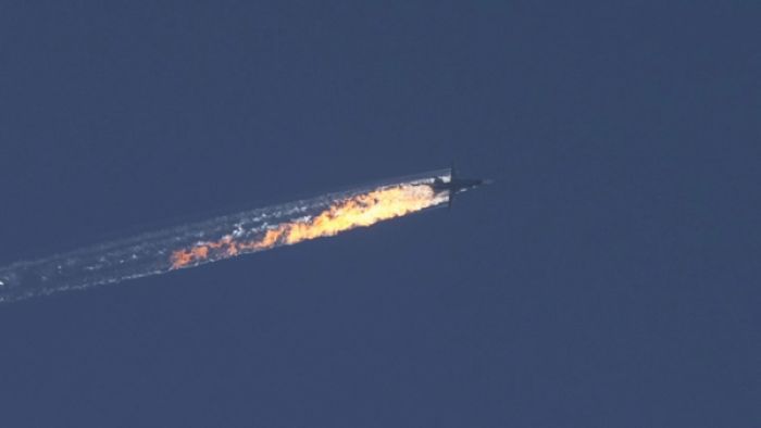 An image from Turkey’s Anadolu Agency captures the moment the Russian military aircraft is plummeting from the sky, trailing thick black smoke and flames against a clear background as it descends rapidly toward the ground.