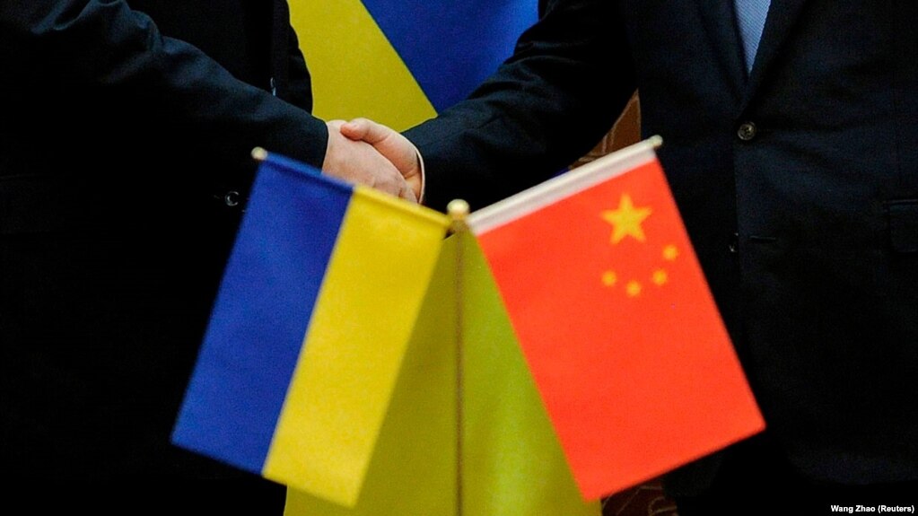 A photograph shows two officials shaking hands behind Chinese and Ukrainian national flags