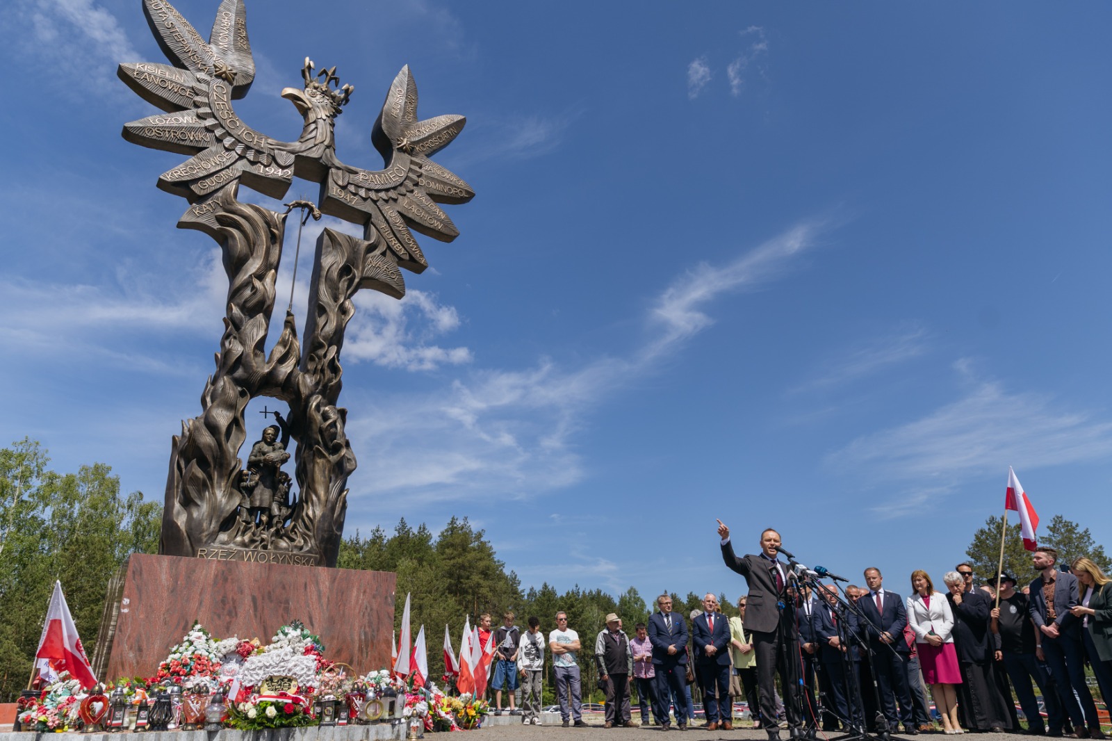 Karol Nawrocki stands near a monument commemorating the Volyn tragedy, paying tribute to the victims during a remembrance event.