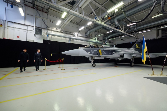 Volodymyr Zelenskyy and Ulf Kristersson while signing the first document paving the way for Ukraine to receive Gripen aircraft are depicted on the background of Gripen