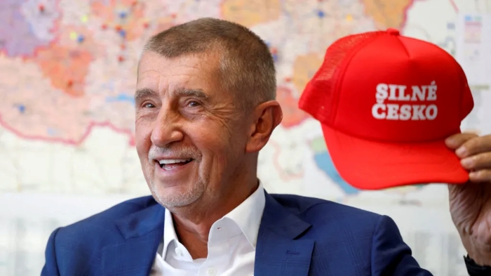 Andrej Babis holding red caps with the slogan “Strong Czechia”