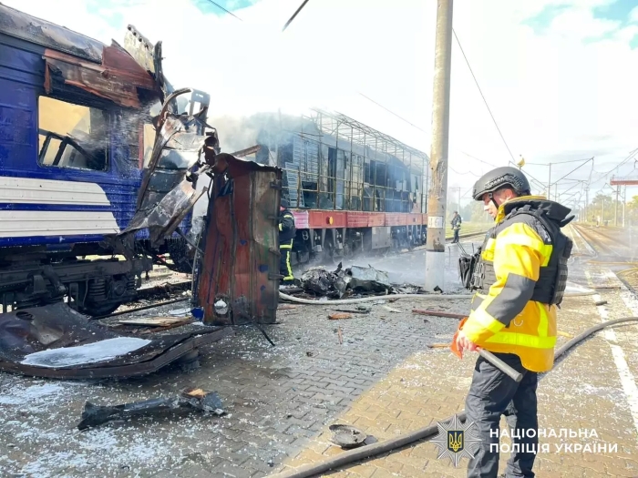 After a Russian airstrike in Ukraine, rescuers and police inspect the wreckage of a destroyed train carriage at a railway station. The photo shows the aftermath of the attack