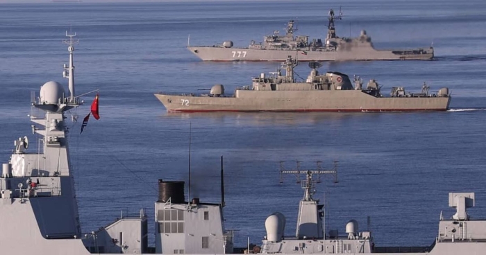 The image shows several Chinese military warships sailing in formation on open water.