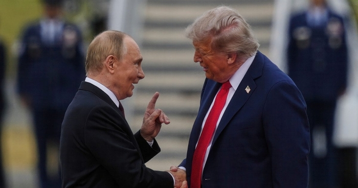 Vladimir Putin and Donald Trump shake hands and engage in conversation during an official meeting