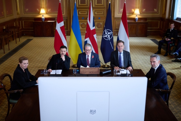European leaders are depicted sitting around the table on the background of flags during the Coalition of the Willing meeting in London