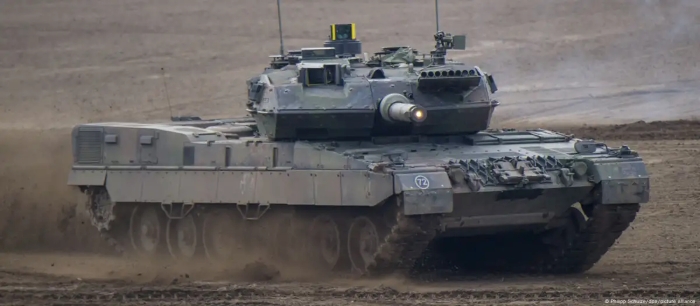A German Leopard 2 main battle tank drives through rough terrain during military exercises, showcasing its power, speed, and advanced armor. The image highlights modern NATO defense technology and battlefield readiness.