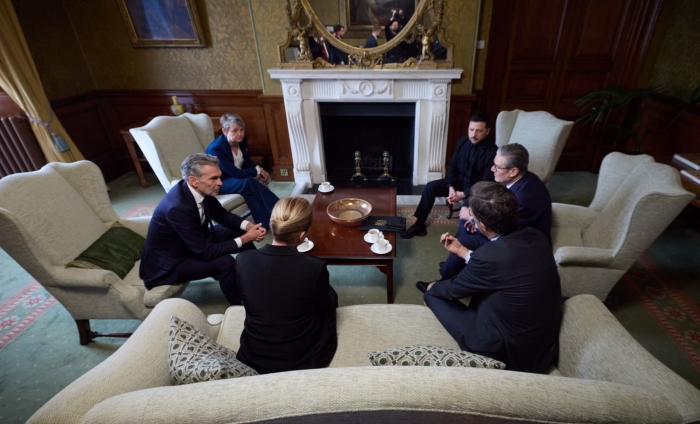 Coalition of willing representatives are sitting around the table.
