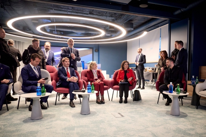 The photo shows a high-level Spanish–Ukrainian technology meeting hosted at the Indra Group facilities in Madrid. A group of senior officials and defense-sector leaders are seated in a modern conference space, arranged in a semi-formal discussion format.