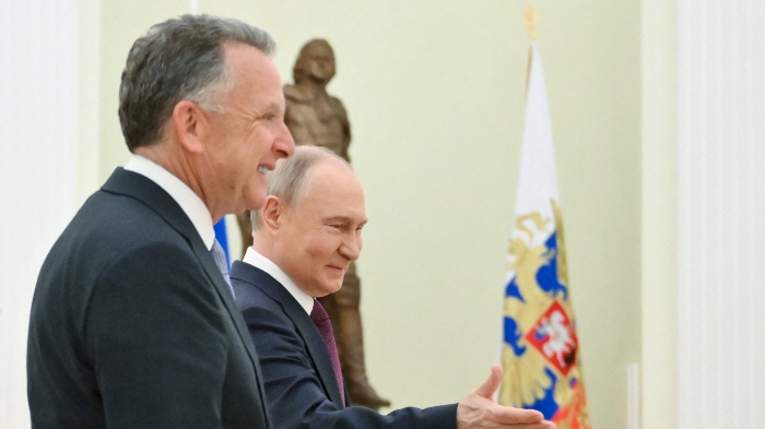This picture shows Putin and US President Donald Trump's special envoy Steve Witkoff smiling on the background of Russian flag