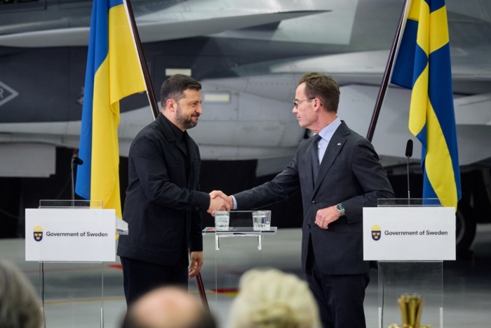 Ukrainian President Volodymyr Zelenskyy and Swedish Prime Minister Ulf Kristersson are pictured signing Gripens deal on the background of jets