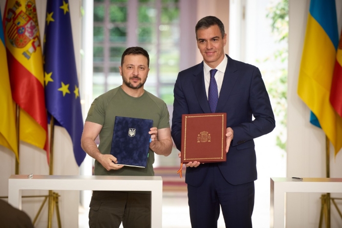President of Ukraine Volodymyr Zelenskyy and Prime Minister of Spain Pedro Sánchez are depicted with the agreement on security cooperation in 2024 on the background of flags