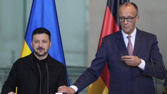 The picture shows German Chancellor Friedrich Merz and Ukraine's President Volodymyr Zelenskyy on tribunes during the press conference