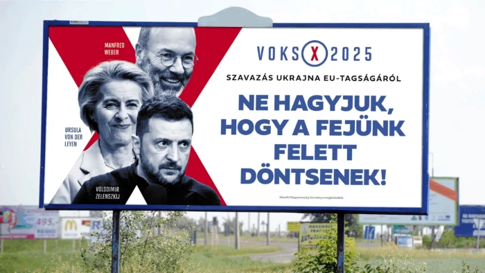 A political billboard featuring three individuals with their names printed beside them and bold Hungarian text about voting on Ukraine’s EU membership in 2025. The design uses red, white, and blue colors with a prominent “Voks 2025” logo and a large slogan urging people not to let decisions be made over their heads. The billboard stands outdoors along a roadside with other signs visible in the background.