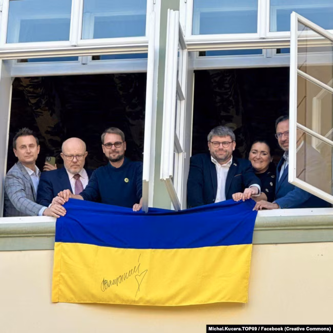 Opposition deputies hang the flag of Ukraine from the window of the Czech Parliament building, Prague, on November 7, 2025