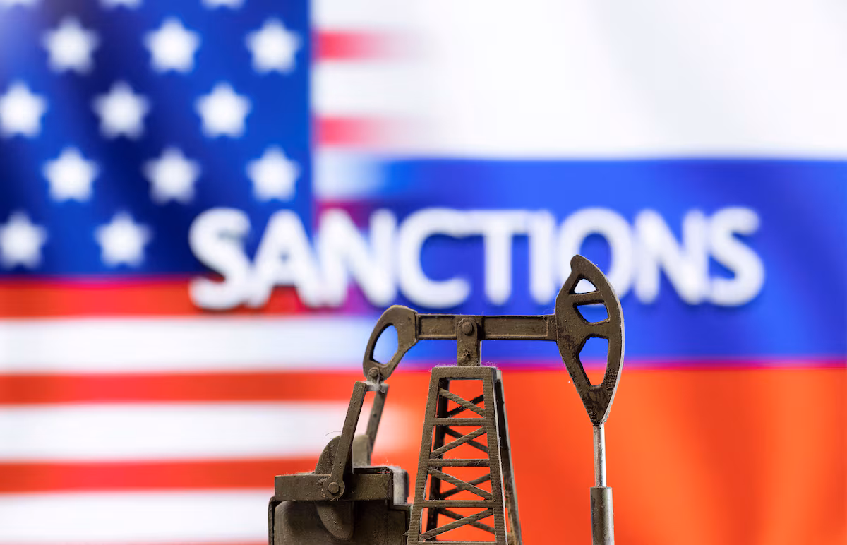 Illustrative photo. A model of a pump jack is seen in front of the displayed word "Sanctions", U.S. and Russia flag colours in this illustration taken March 8, 2022 / REUTERS, Dado Ruvic