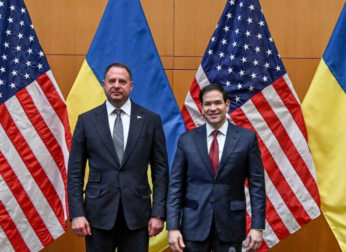 The picture shows US Secretary of State Marco Rubio and Head of the Office of the President of Ukraine standing on the background of flags and smiling