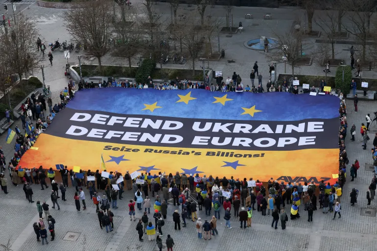Ukrainian activists deploy a massive banner urging European leaders to seize frozen Russian assets in Brussels, Belgium, on March 5, 2025 / Yves Herman, Reuters