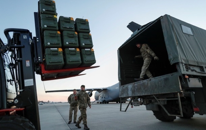 Ukrainian military personnel unload pallets of ammunition from a cargo aircraft at an airbase