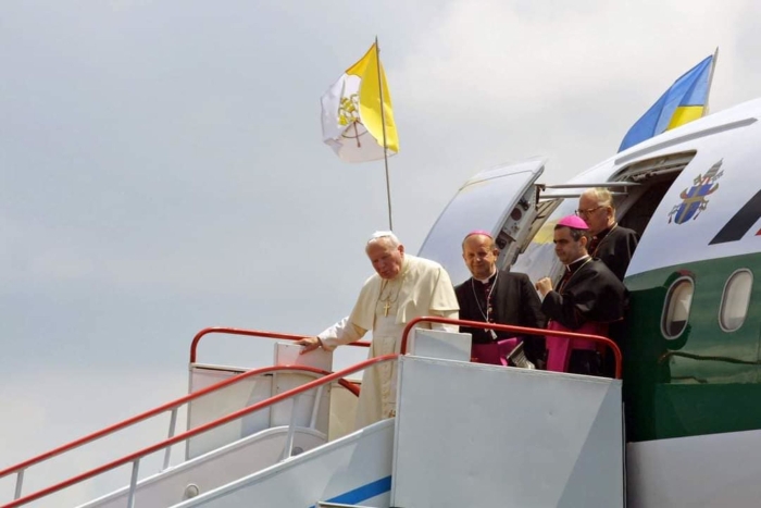 The image shows a high-level Vatican visit to Ukraine, emphasizing historical and symbolic presence rather than a current political event.Pope John Paul II is pictured descending from a Vatican aircraft upon arrival in Ukraine, accompanied by senior Catholic clergy.