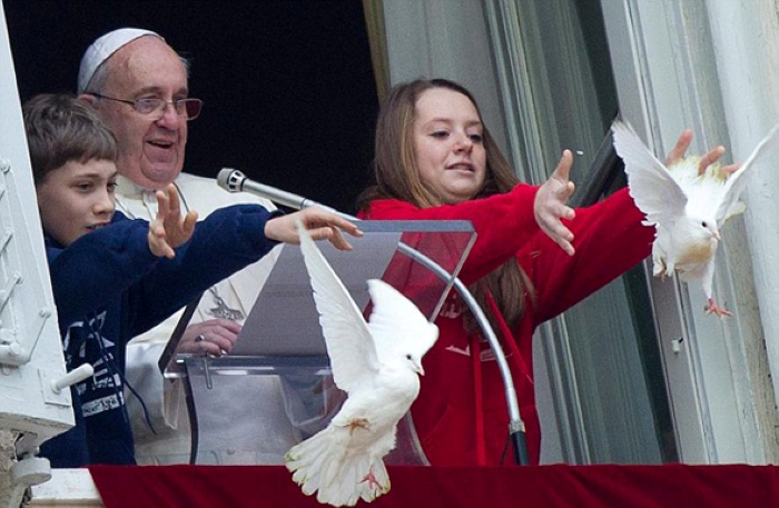 A symbolic Vatican moment featuring the Pope alongside children releasing white doves from a balcony during a public address.