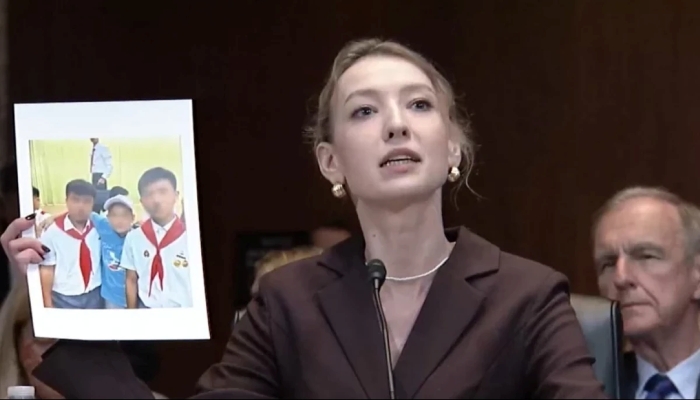 The picture portrays Kateryna Rashevska, expert on international justice and legal analysis at the Regional Center for Human Rights showing pictures of kidnapped Ukrainian children in North Korea