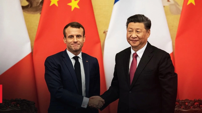 The picture portrays French President Emmanuel Macron and Chinese President Xi Jinping shaking hands