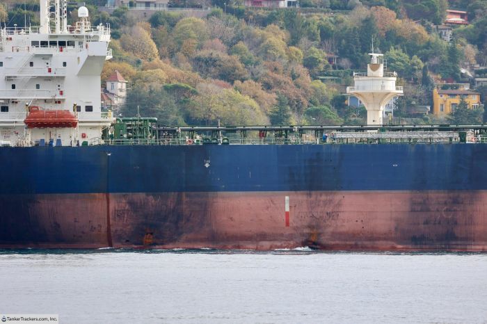 Image shows a large Russian oil tanker with visible hull damage and discoloration along the waterline