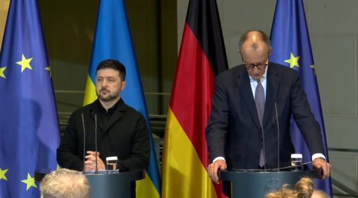 The picture shows Volodymyr Zelenskyy and Freidrich Merz during the press conference on the background of flags