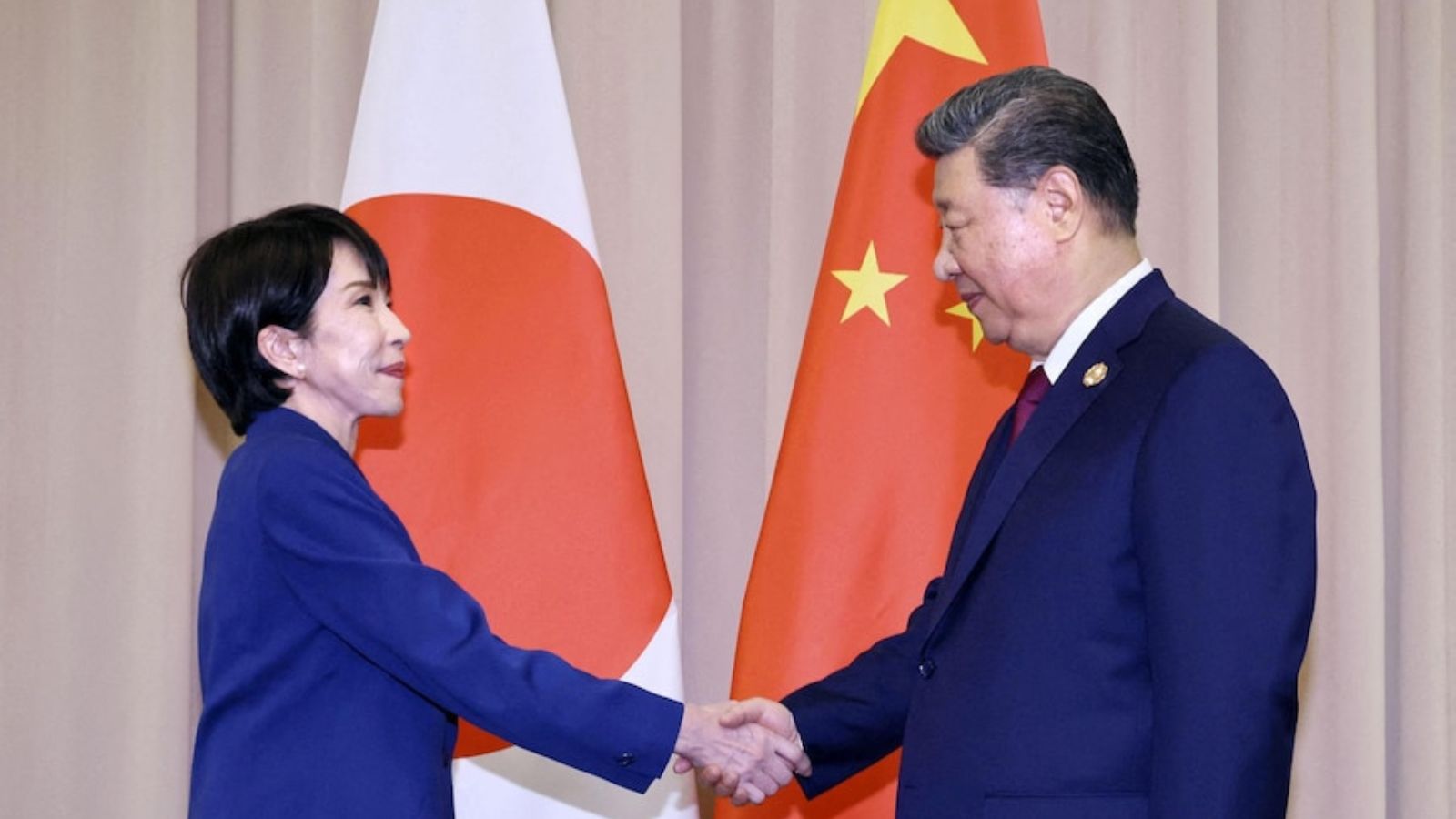 Japanese Prime Minister Sanae Takaichi shakes hands with Chinese leader Xi Jinping during an official meeting.