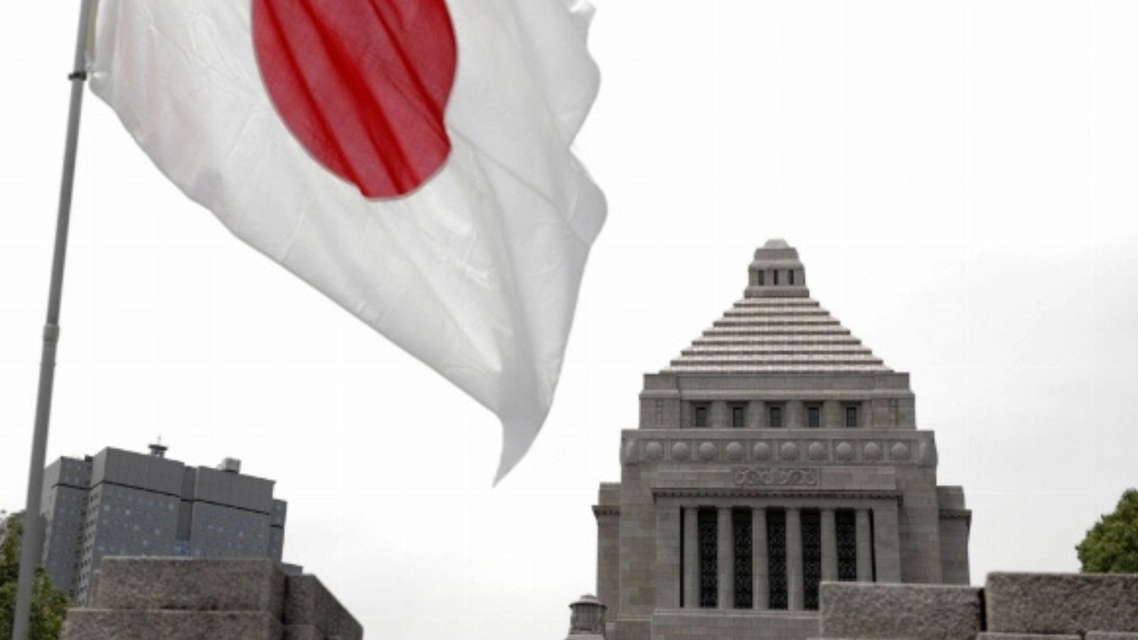 The national flag of Japan waving in front of the National Diet building in Tokyo.