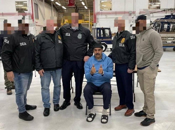 Maduro poses with a thumbs-up gesture while surrounded by several law enforcement officers wearing DEA jackets