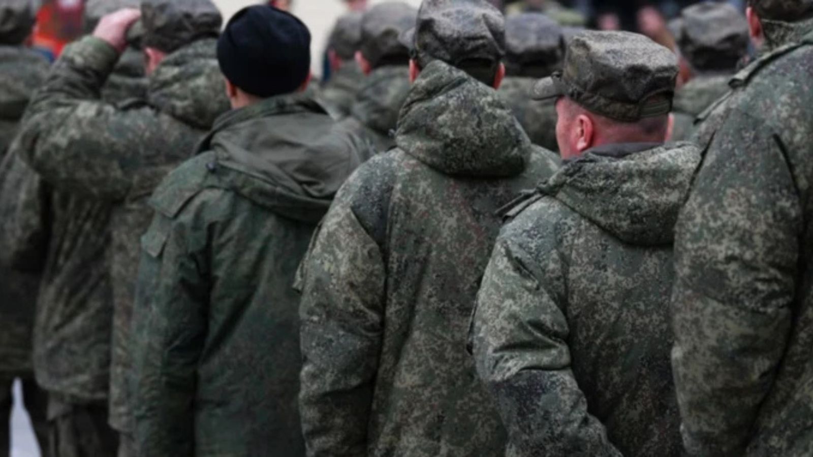 A group of Russian soldiers in camouflage standing in a line with their backs to the camera.