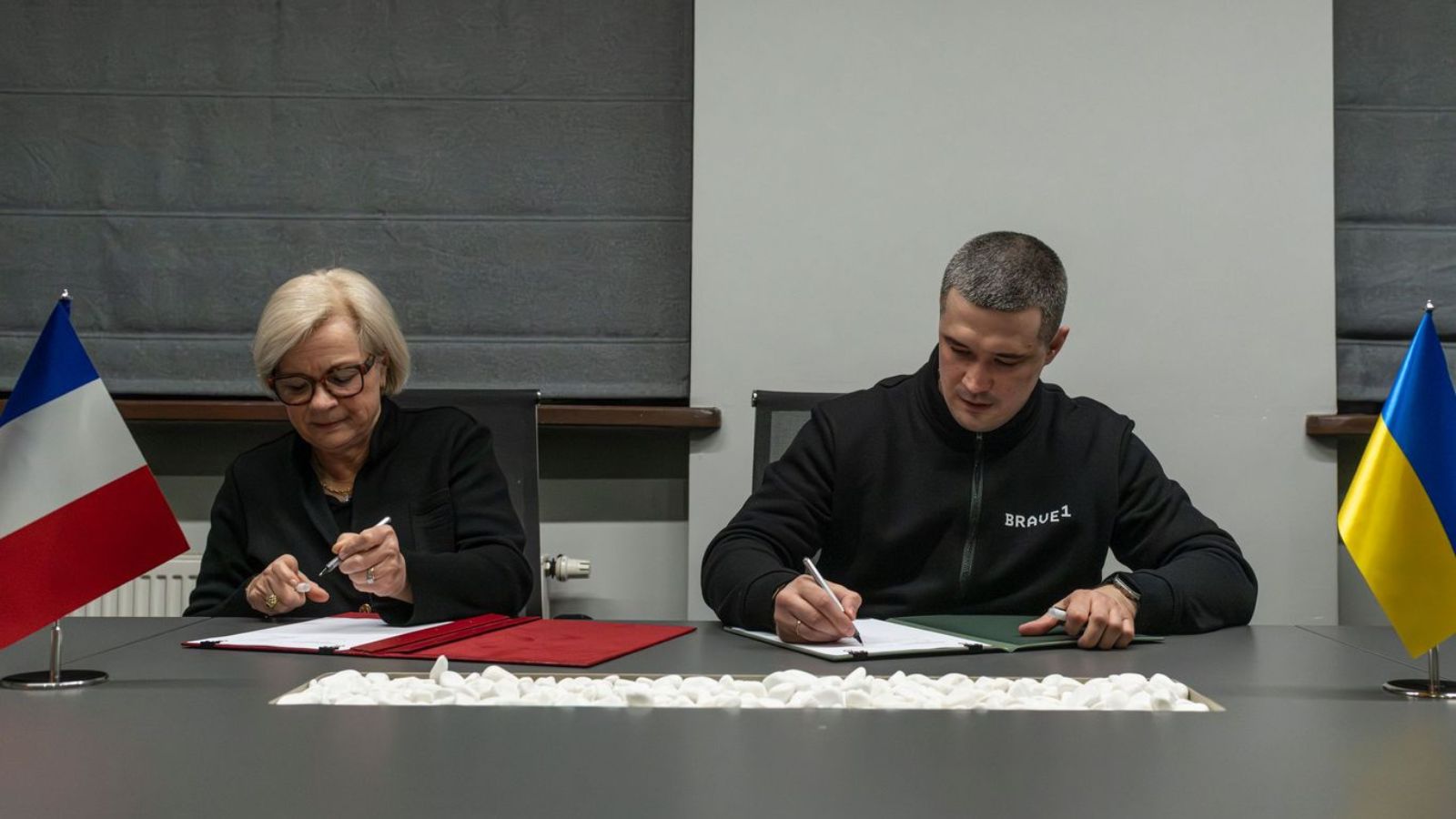 Міністр оборони України Михайло Федоров та міністерка збройних сил Франції Катрін Вотрен сидять за столом і підписують офіційні документи
