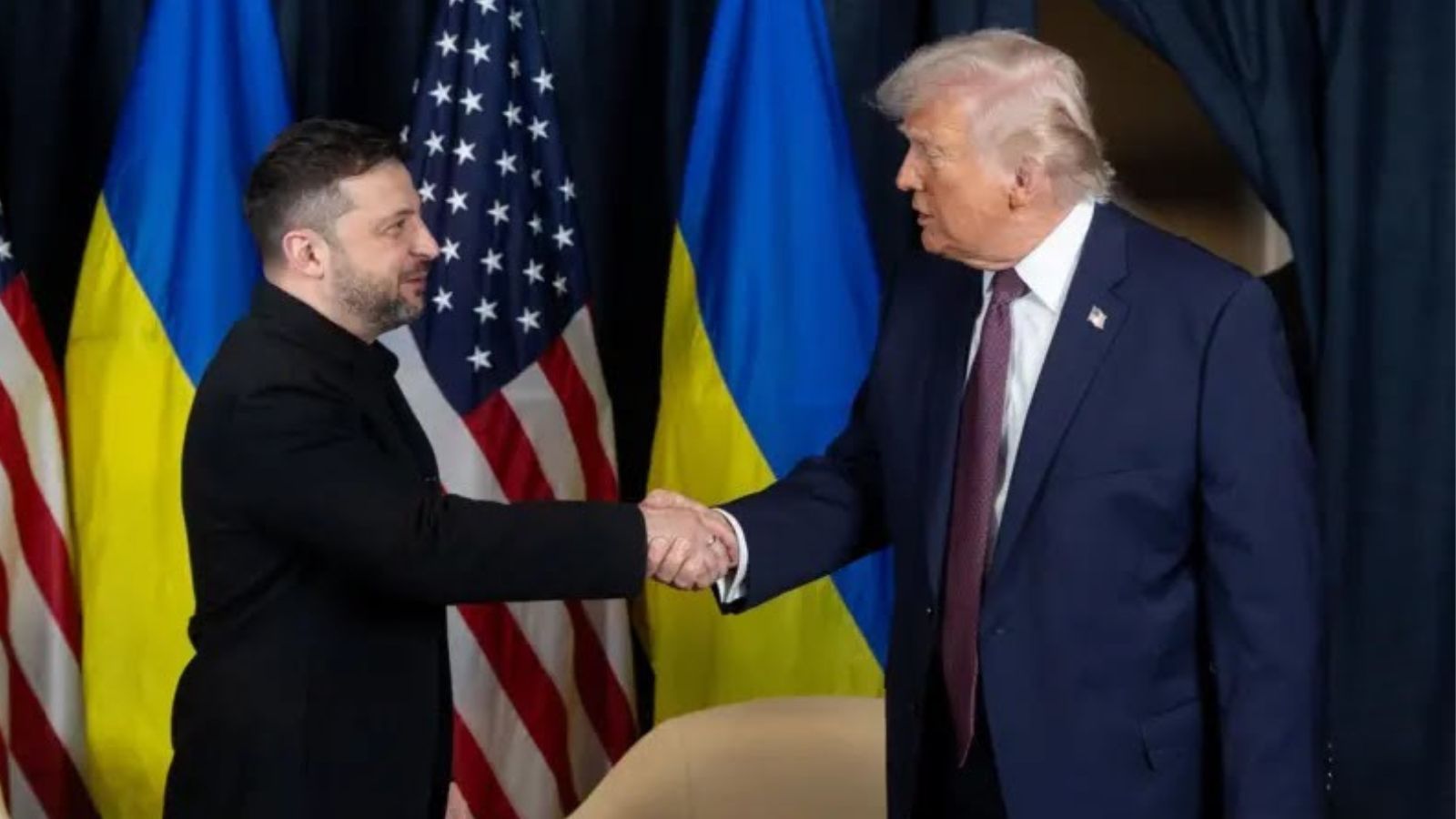 Volodymyr Zelenskyy and Donald Trump shaking hands in front of Ukrainian and US flags during their meeting in Davos.