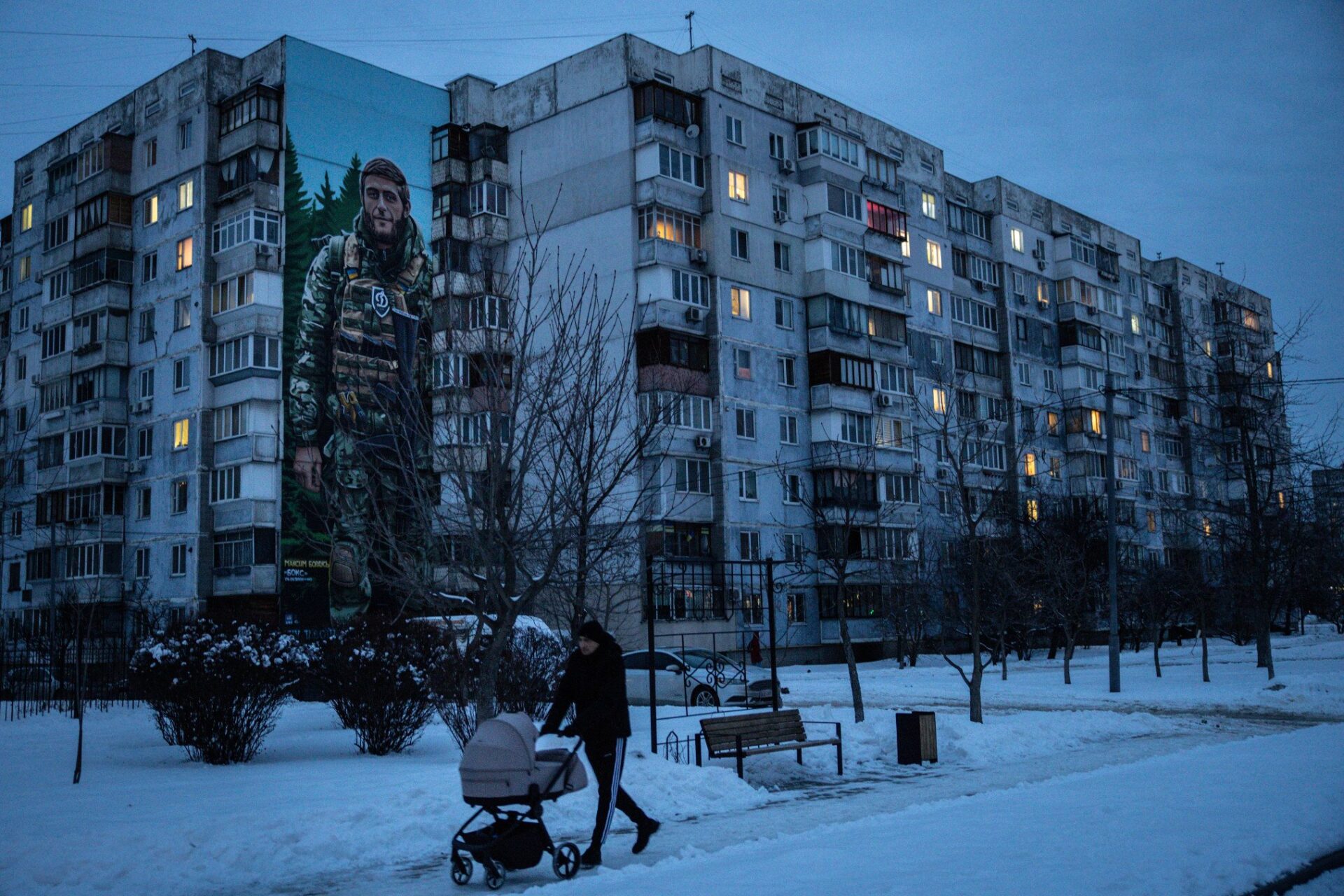 A man walks past a building suffering from limited electricity in Kyiv