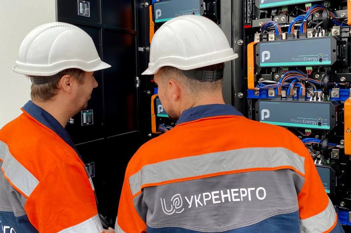 Ukrenergo employees are standing next to equipment