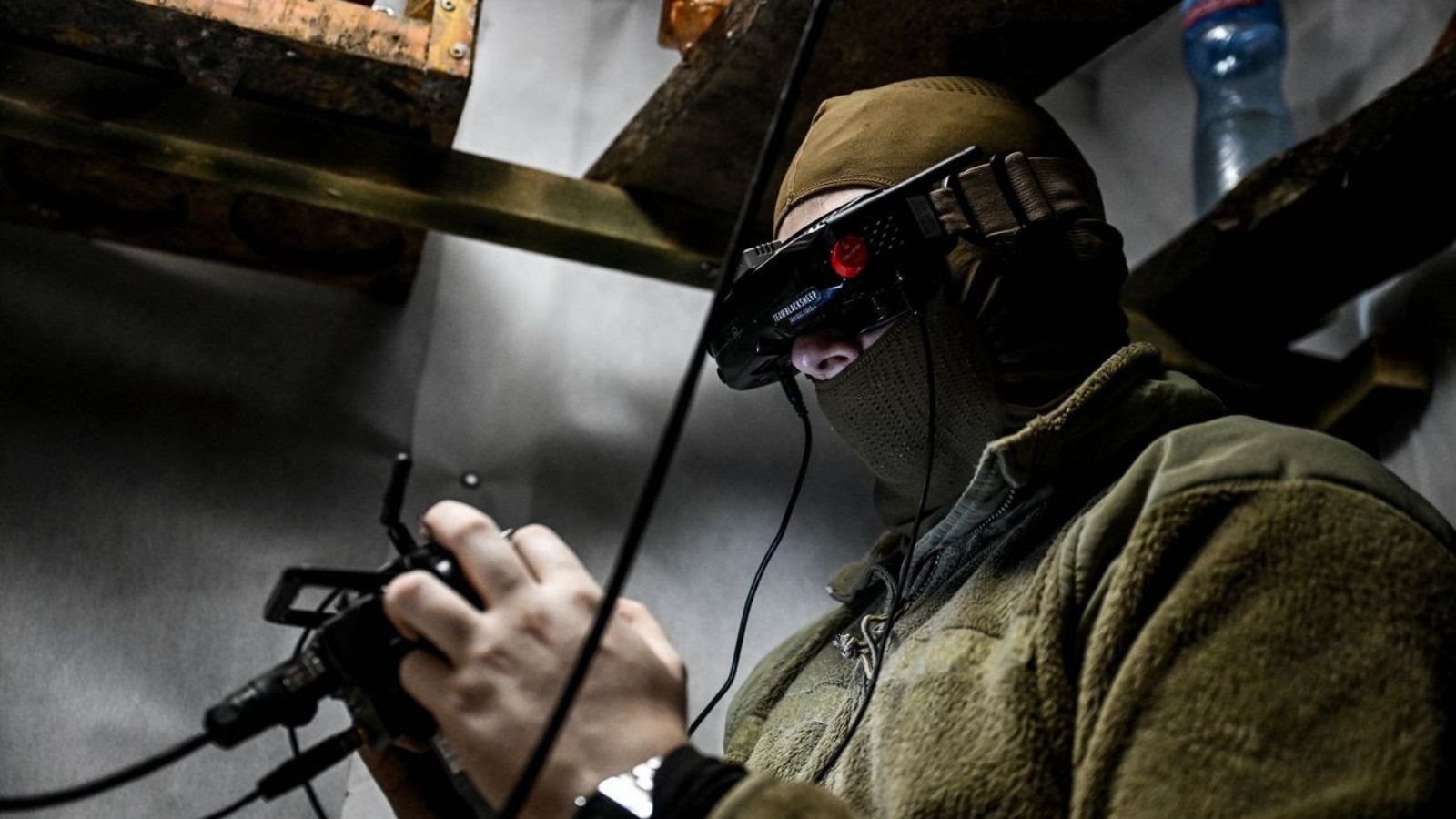 An operator of the Ukrainian Unmanned Systems Forces wearing FPV goggles and using a remote controller to fly a drone.