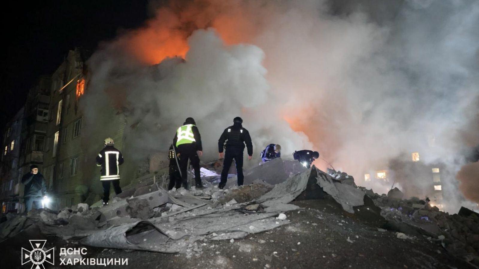 Рятувальники працюють на руїнах багатоповерхового житлового будинку в Харкові, охопленого димом після влучання ракети