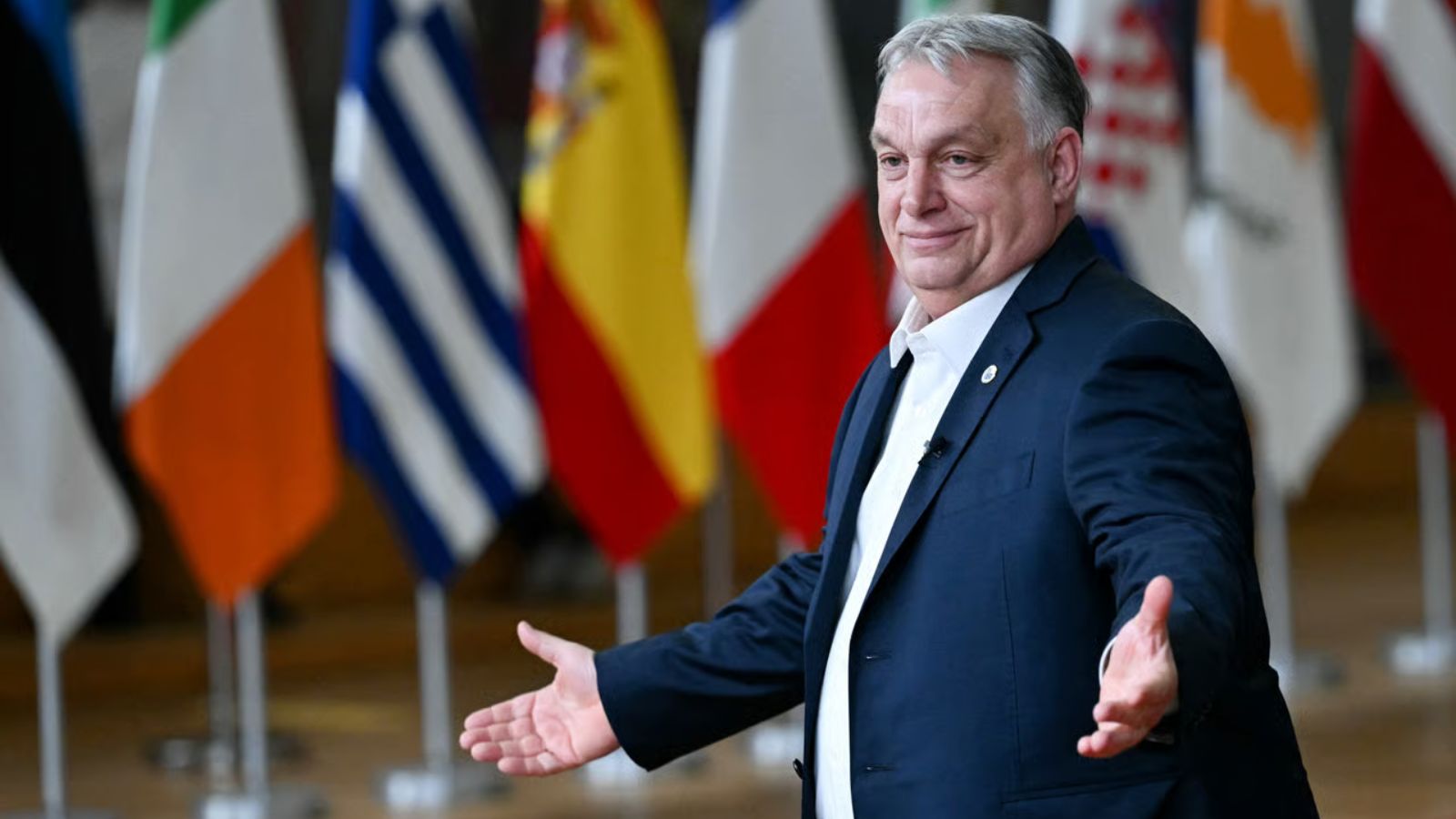 Hungary’s Prime Minister Viktor Orban stands behind microphones and speaks during a press conference in Brussels.