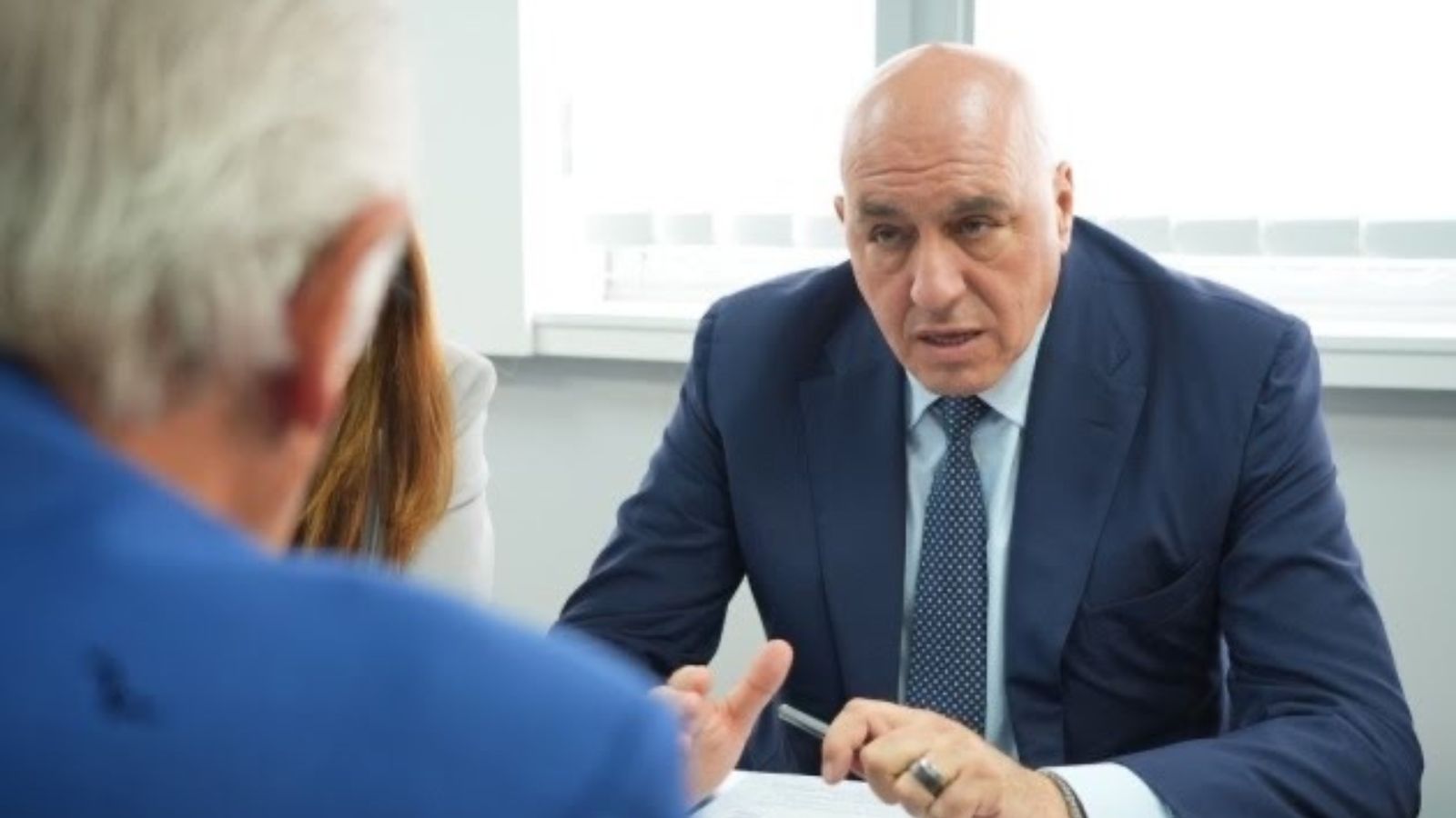 Guido Crosetto speaking during an official meeting while sitting at a desk.