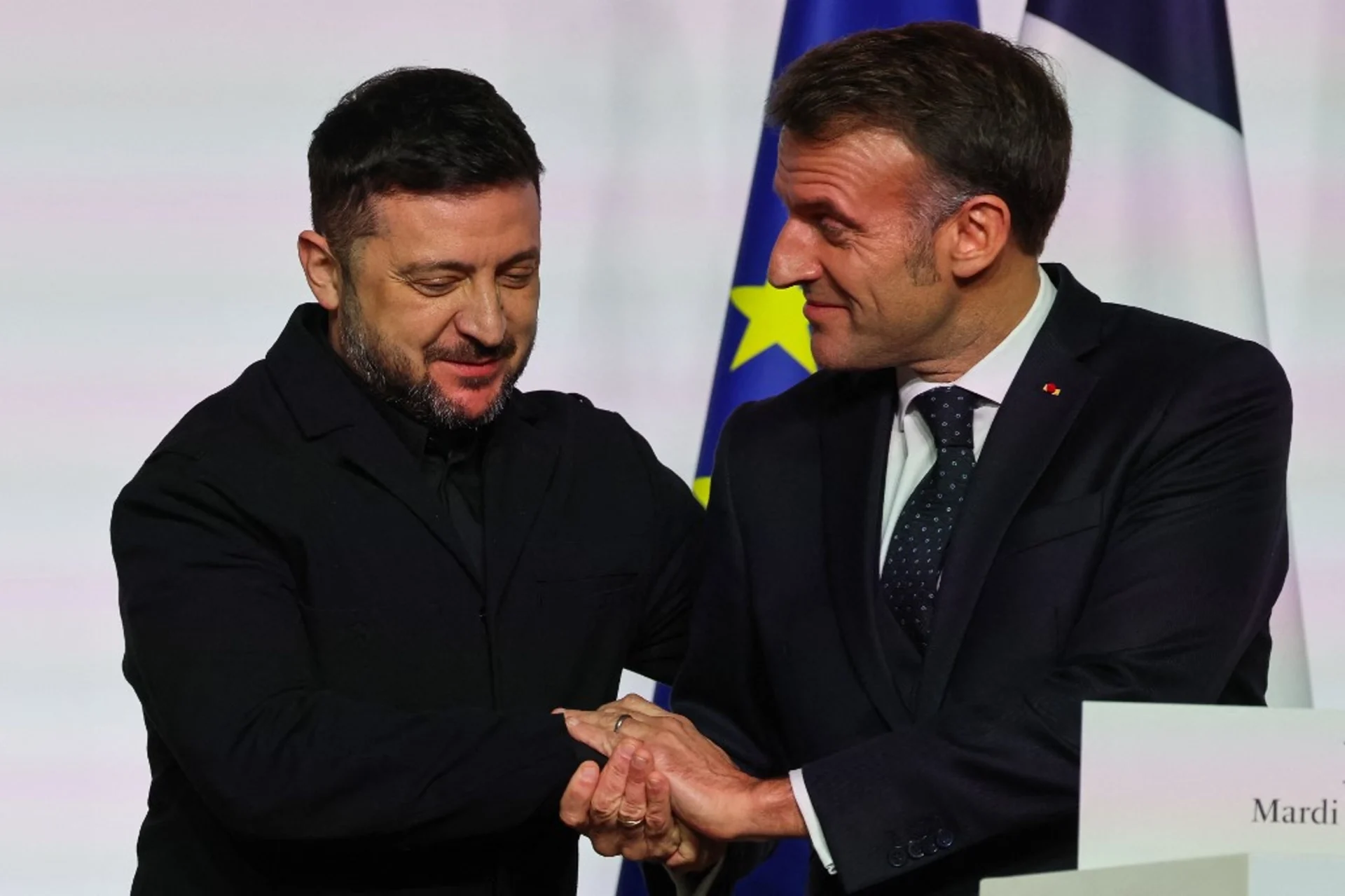 Volodymyr Zelenskyy and Emmanuel Macron shake hands