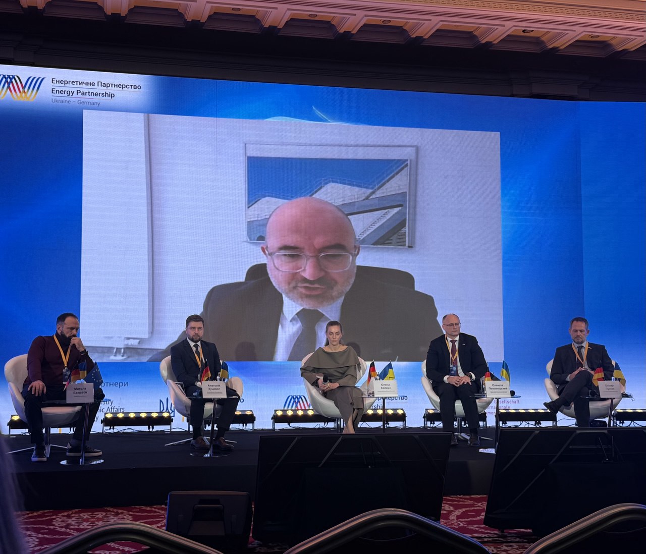 First panel participants. Online - Dr. Thomas Steffen, State Secretary, German Federal Ministry for Economic Affairs and Energy, from left to right: Mykola Baksheyev, City Mayor of Zlatopil; Anatolii Kutsevol, Deputy Minister of Energy of Ukraine for European Integration, MinEnergo; Olena Sotnyk, Rasmussen Global; Oleksiy Povolotskiy, Head of the Office for Energy Infrastructure Recovery, DTEK; Oliver Gierlichs, CEO Bayer UKR, AHK Ukraine