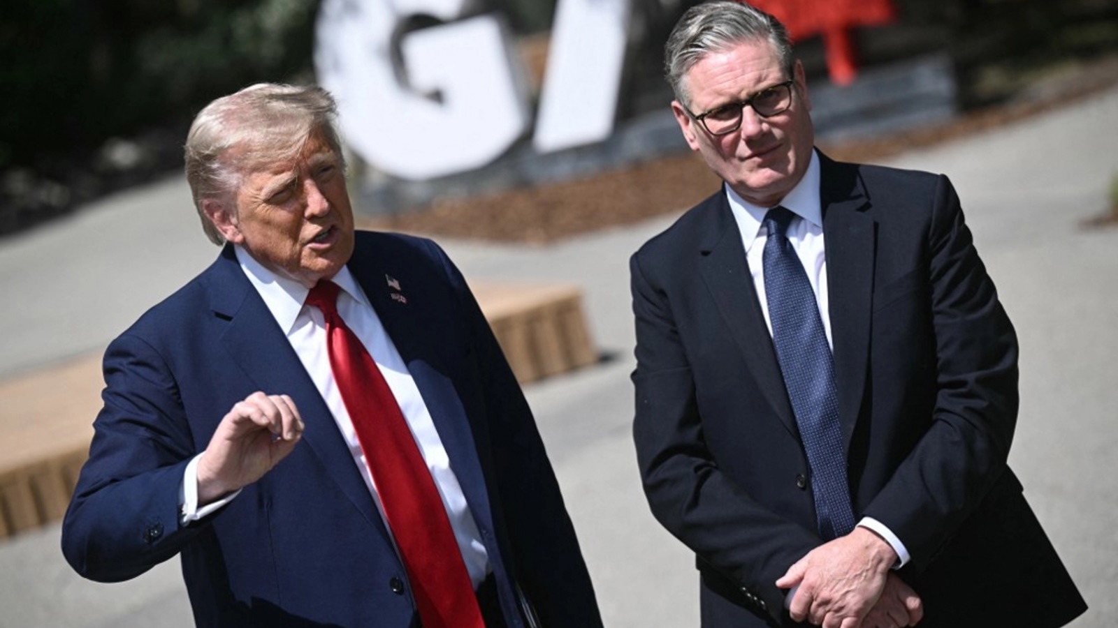 A photograph of UK Prime Minister Keir Starmer and US President Donald Trump standing together and speaking outdoors.