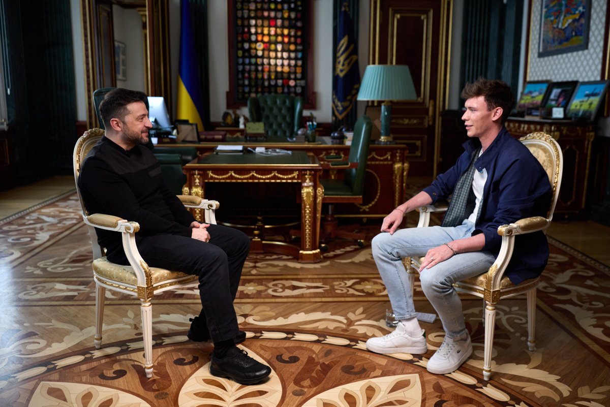 Volodymyr Zelenskyy and Caolán Robertson are sitting on a chair and talking
