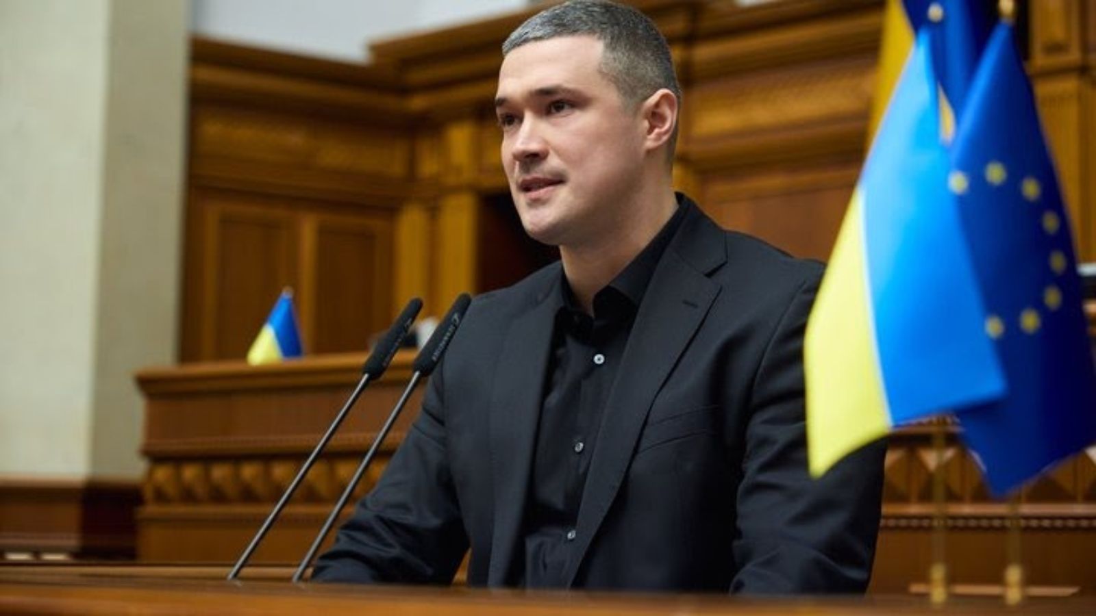 Mykhailo Fedorov speaking at a podium with the flags of Ukraine and the European Union in the background.