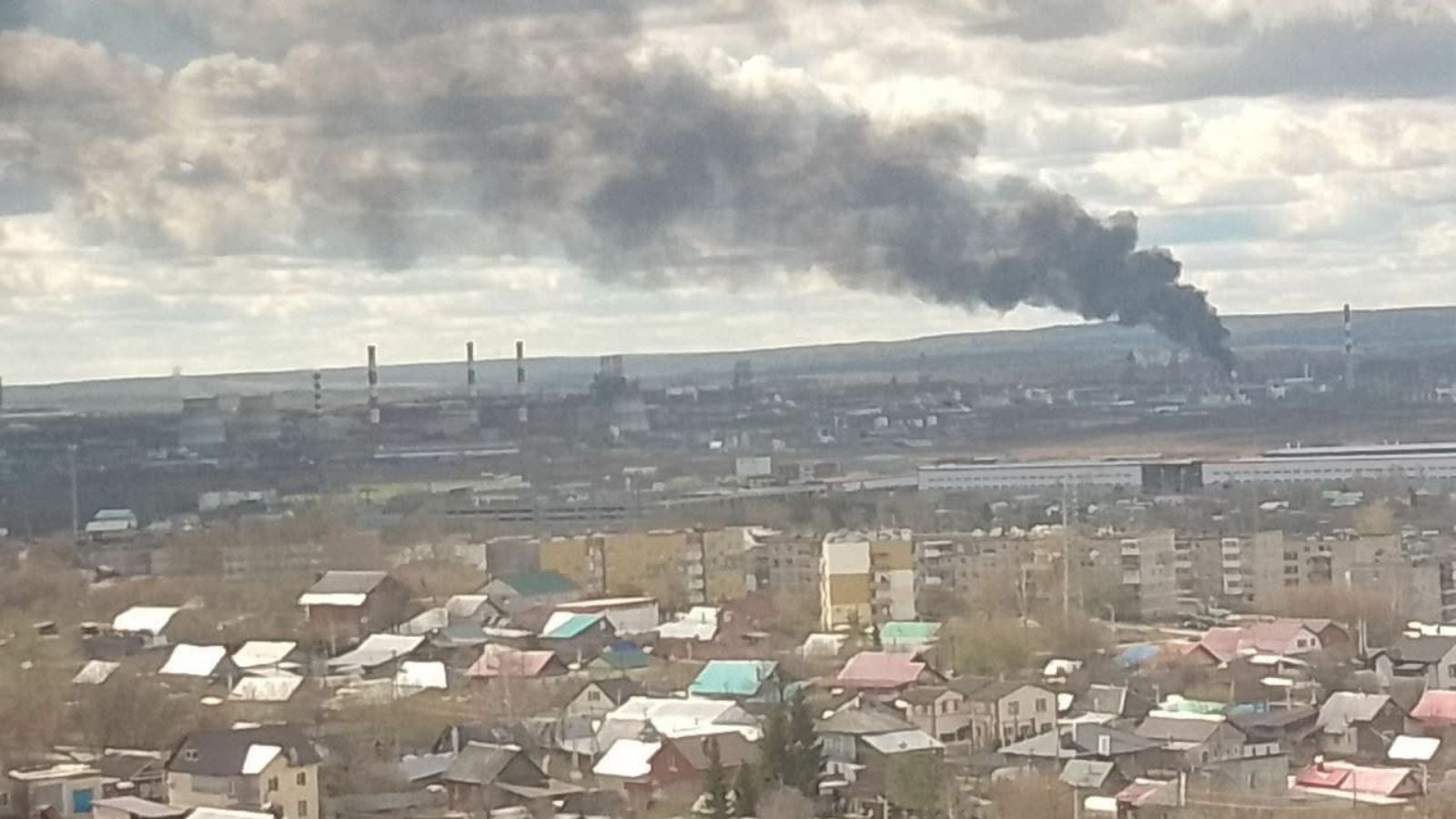 A panoramic view of the industrial zone in Perm, with a column of black smoke billowing from the refinery following the explosions.
