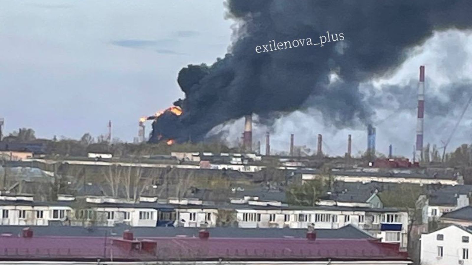 Близький план масштабної пожежі на промисловому об'єкті: величезне помаранчеве полум'я та клуби чорного диму охопили резервуари та металеві конструкції НПЗ.