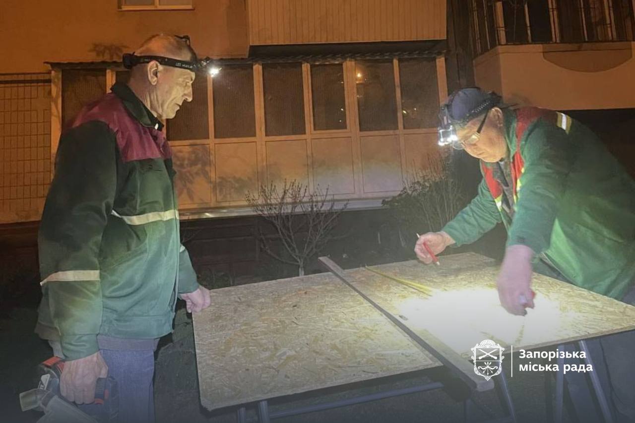 Utility workers in Zaporizhzhia work on restoring windows after the Russian attack on May 7